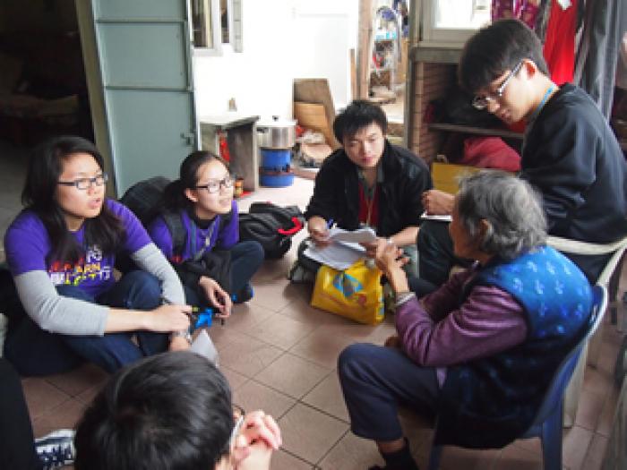 Volunteers interviewing a local elder about her views on community needs