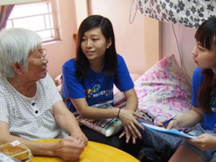 Our student volunteers chatting with the elder and giving a bag of rice