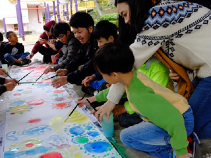 Both students and volunteers drawing a beautiful picture together