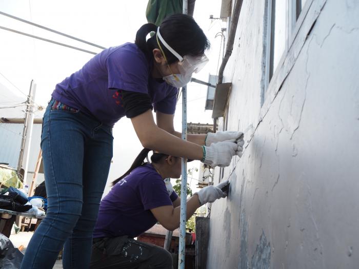 Volunteers refurbishing stilt houses for the elderly
