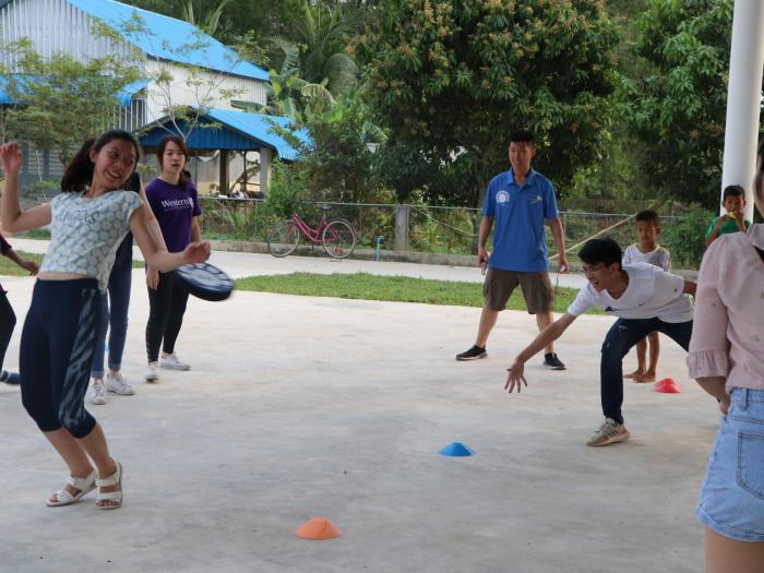 Both volunteers and kids learning how to play dodgebee, a new sport combining frisbee and dodgeball.