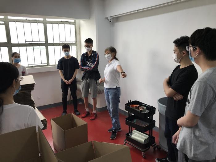 FHK Staff teaching volunteers how to pack food