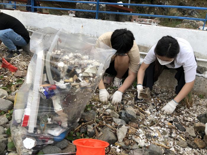 Students picking up polystyrene fragments washed up on the HKUST beach areas
