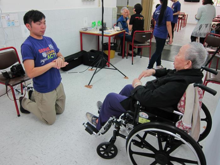 volunteer teaching elder on wheelchair how to pose