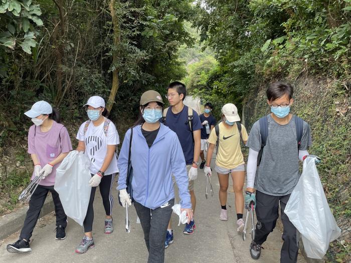 Volunteers actively scanning for trash along the trail