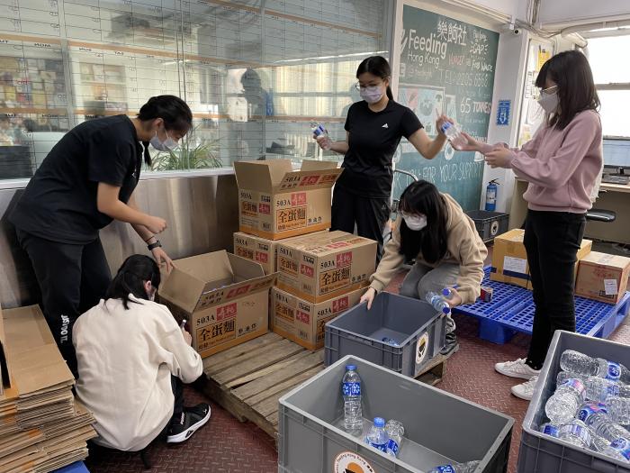 Volunteers repacking bottles of water into boxes