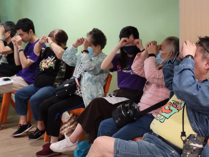 Seniors taking part in eye massaging exercises