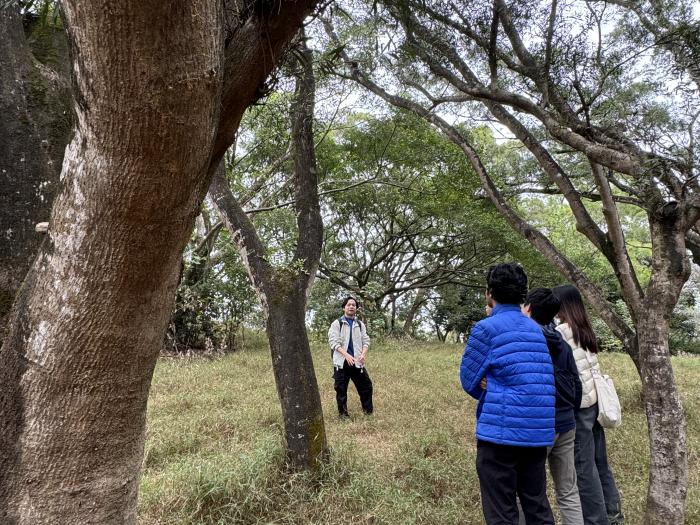The guide explaining interconnectedness of nature and community to the students