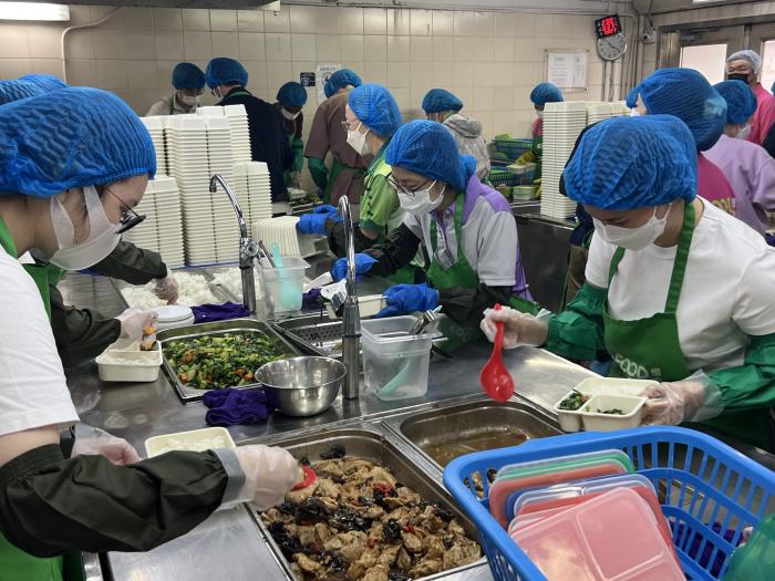 Volunteers preparing meal boxes using donated surplus food
