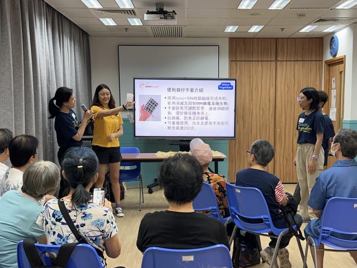 Students distributing sanitary hand pockets to elderly centre