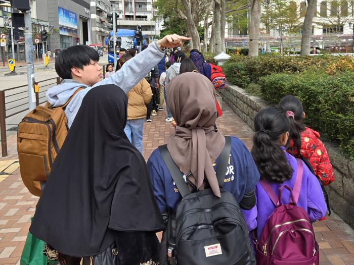 Volunteers accompanying ethnic minority children to hiking trail cleaning in Lei Yu Mun 
