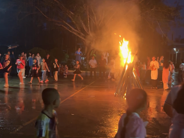 Children and volunteers having farewell campfire