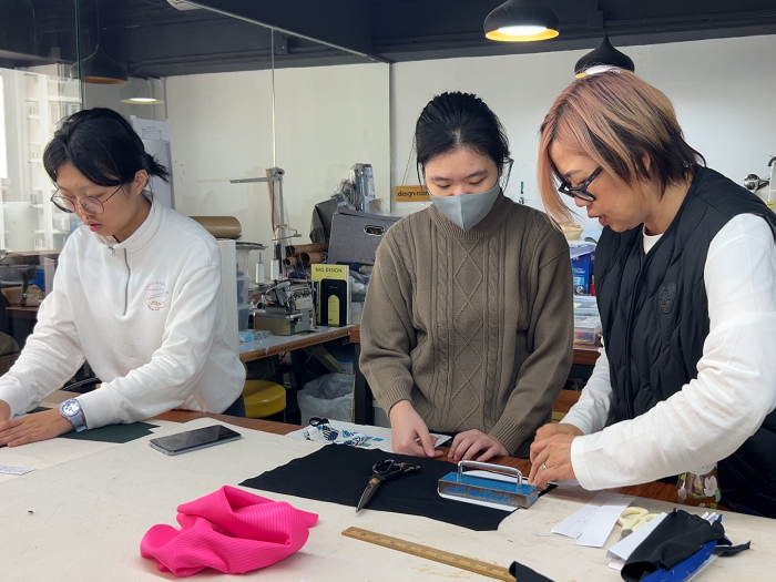 Students learning machine sewing techniques to make their idea into real products