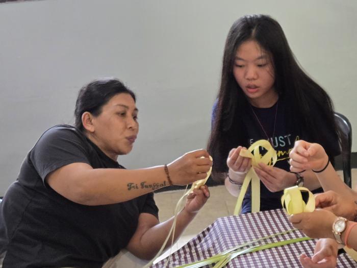 Volunteers learning from Cahaya Mutiara members on how to make traditional local handicrafts 