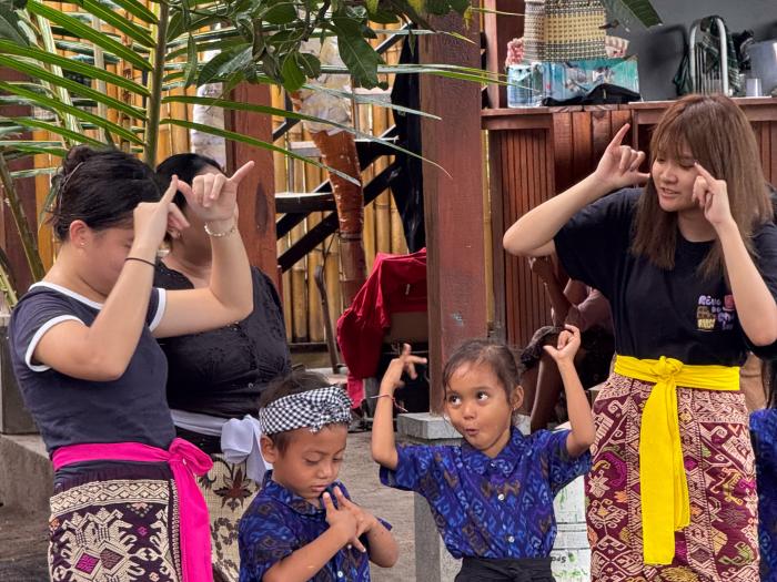 Volunteers teaching kindergarten students English through singing and dancing.