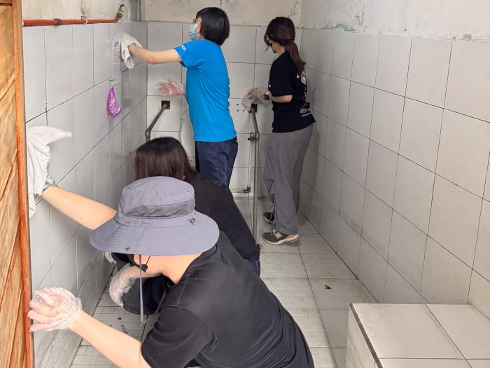 Volunteers assisting residents with physical disabilities in cleaning activities