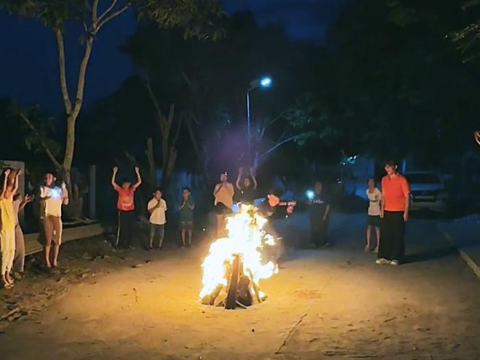 Local children and volunteers celebrating around a campfire on their last night in Tra Vinh