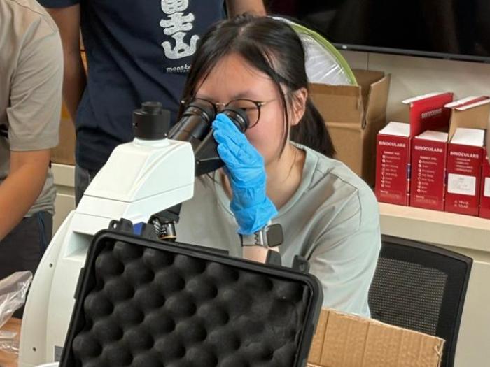 Student using microscope to examine the sample