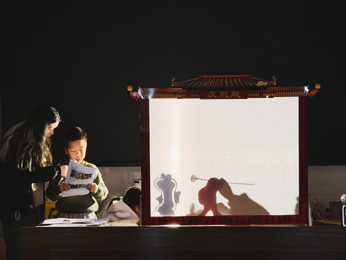 Volunteers guiding children in the art of shadow play.