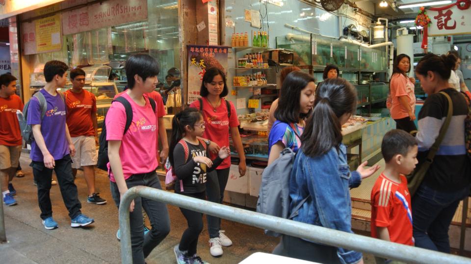 Volunteers and the ethnic minority teenagers walking along Wan Chai District to learn more about the local community