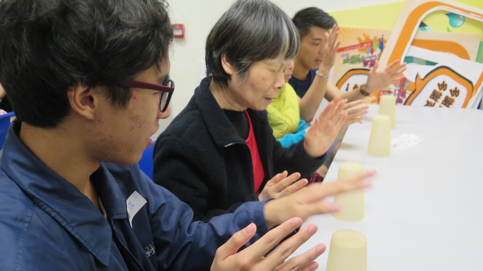 Volunteers teaching the visually impaired people to play the Cup song
