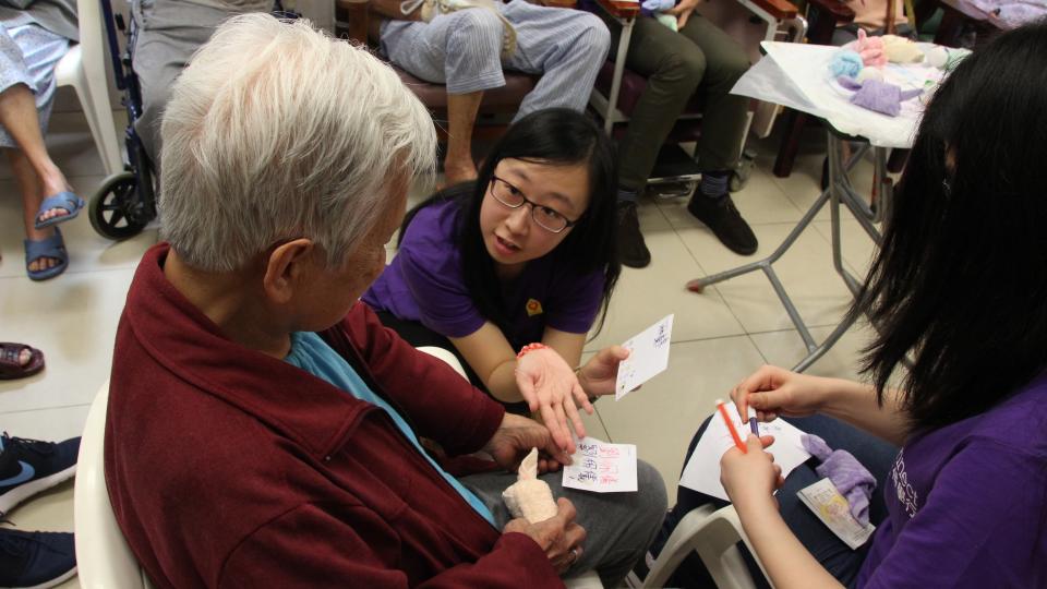 Volunteer telling the elder about the information on the card