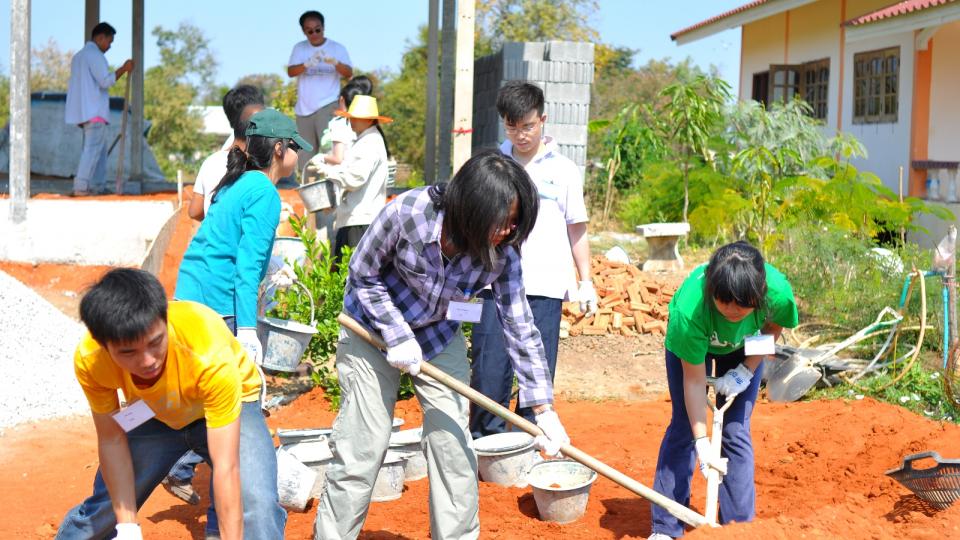 Student volunteers transferring soil into the house