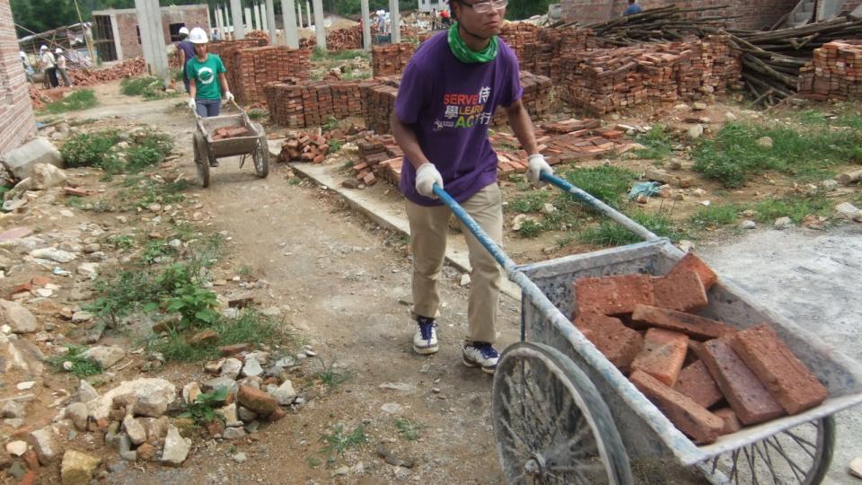 Student volunteers transferring bricks for the houses