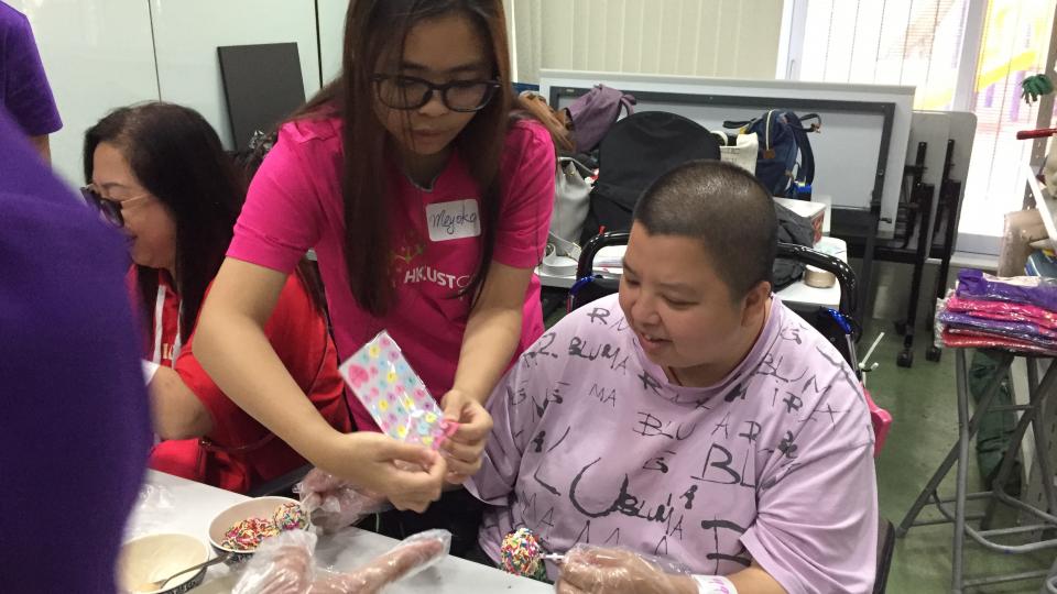 Volunteers and physically challenged adults making the "cake pop" together.