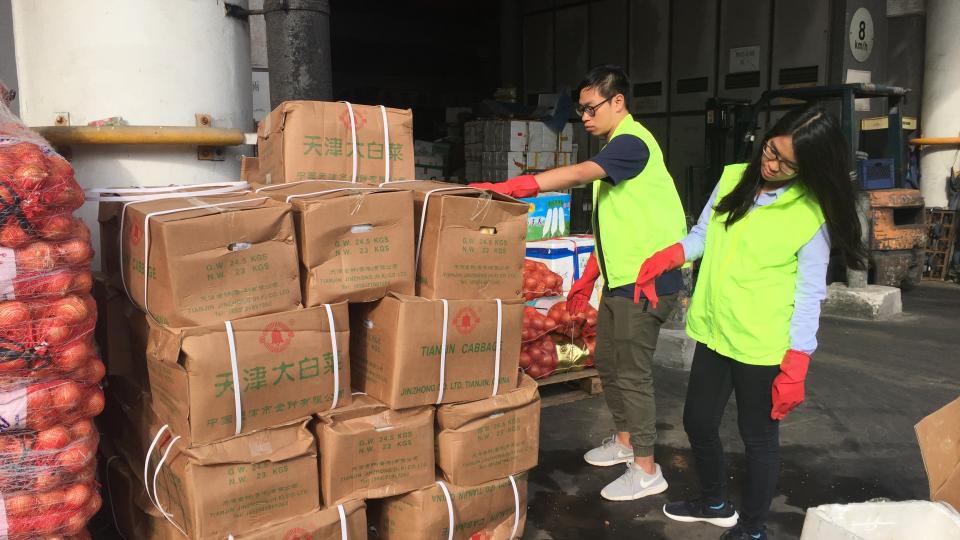 Volunteers estimating the number of boxes of unsold vegetables to be transported to the groups in need