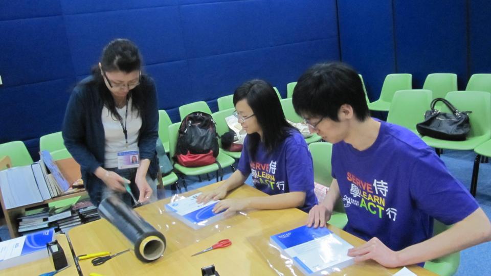 Volunteers learning how to wrap books