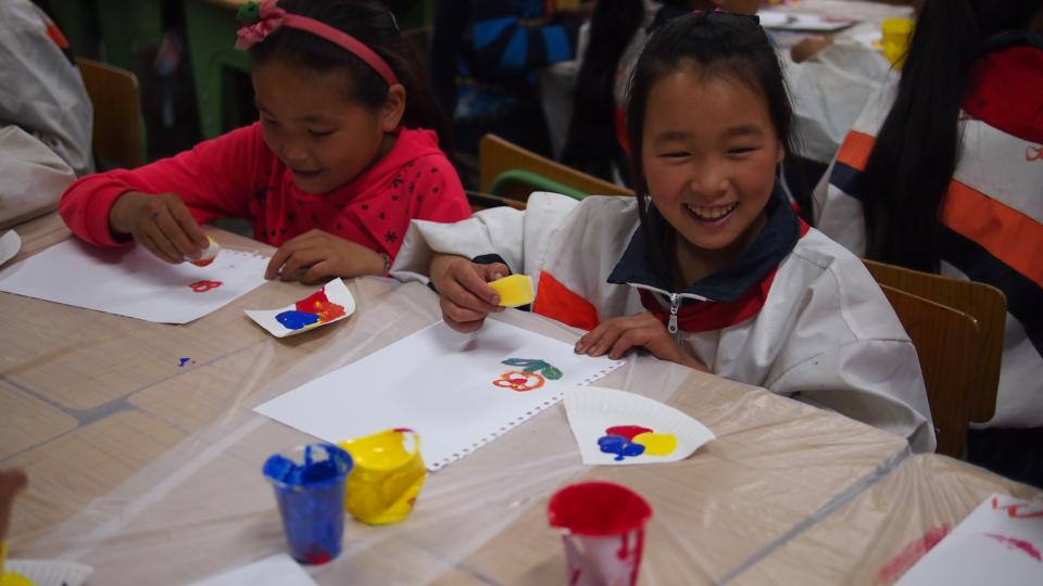 Children learning to draw a picture with sponge