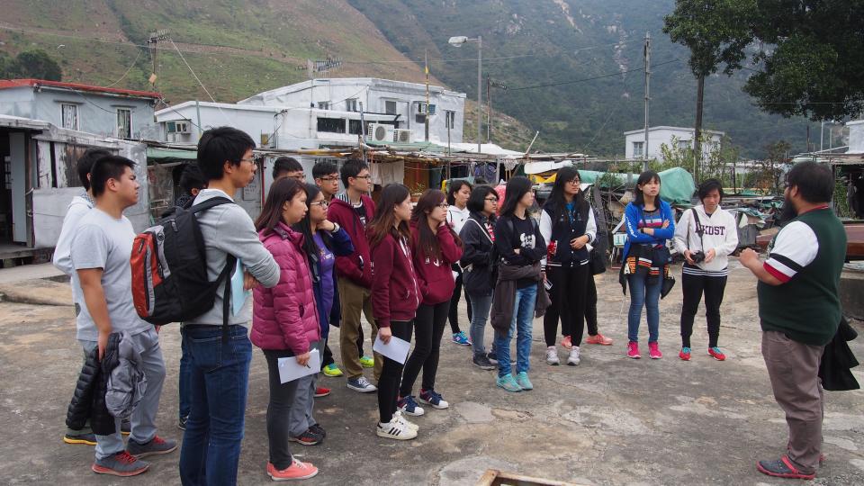 Mr Yuen, staff from YWCA, telling volunteers the history of Tai O