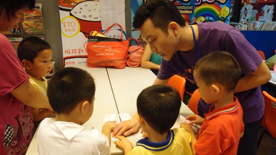 Volunteer teaching a new game to the children