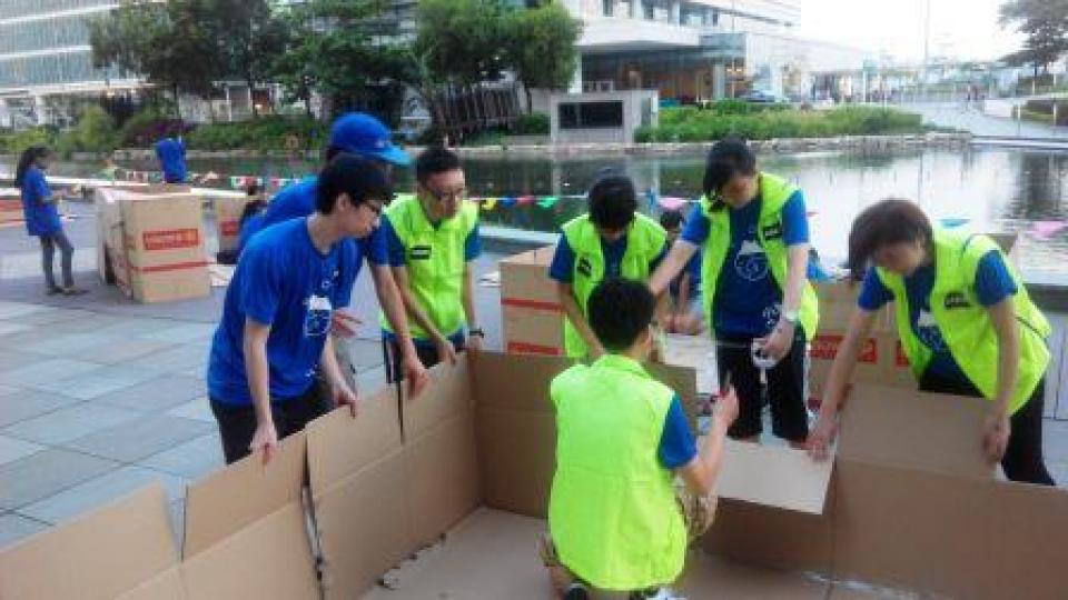 Volunteers helping the participants to build their "paper home"