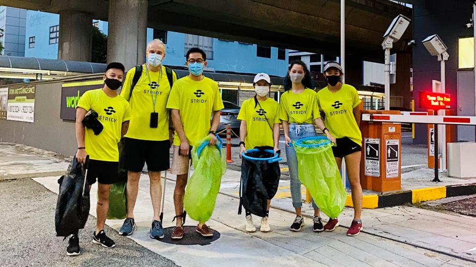 Volunteers taking photos after collecting rubbish in street