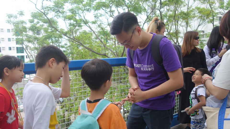 Kids playing games with an HKUST student on campus