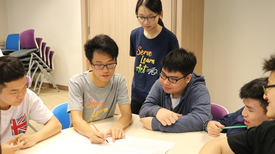 Volunteers helping students with their homework.