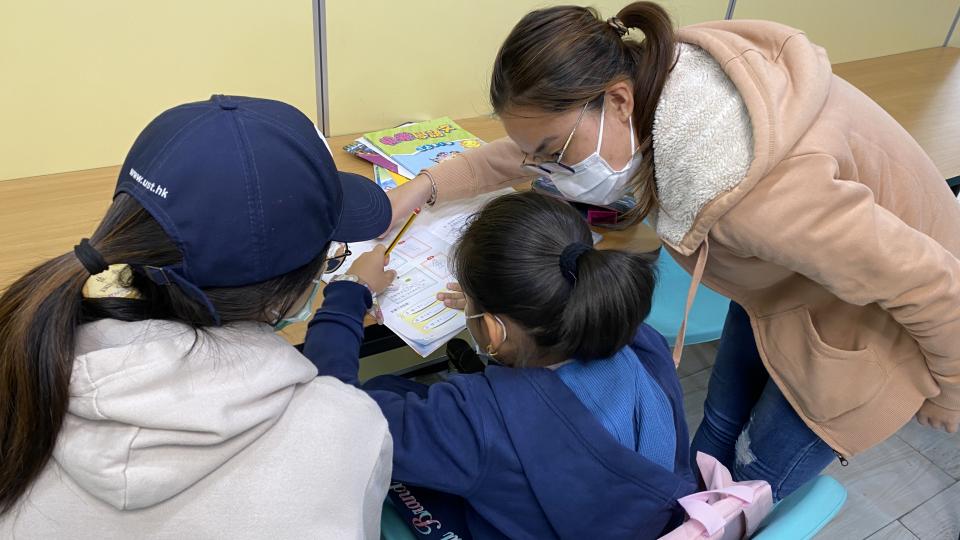 Volunteers helping students with their homework.