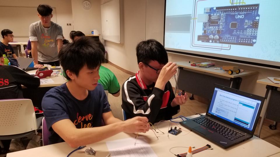 Volunteer helping a student with his STEM project