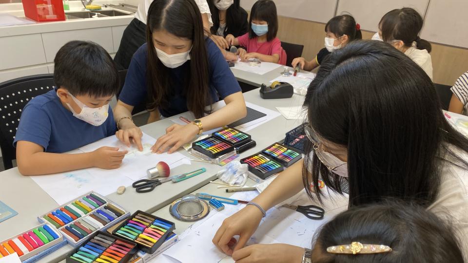 Volunteers teaching children how to make crafts