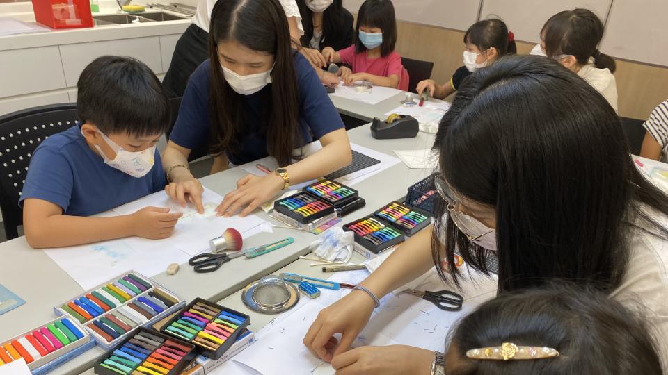 Volunteers teaching children how to make crafts