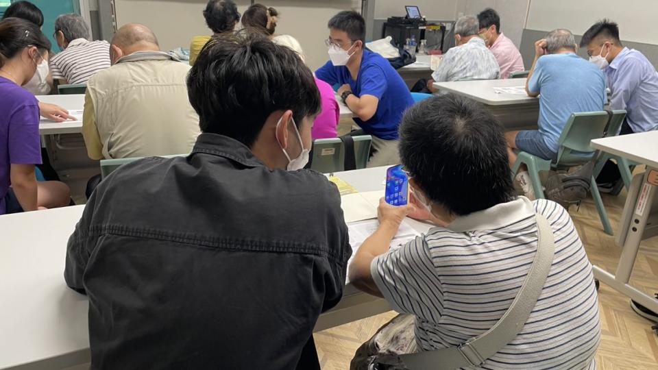 Volunteers guiding the elderly to use smartphones