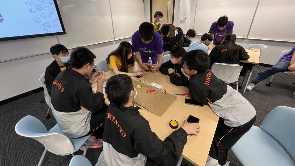 Volunteers guiding students in constructing an Arduino Self-Driving Car