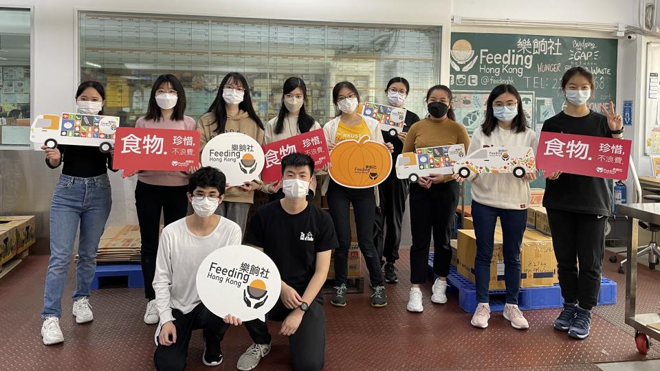 Group photo of volunteers with props in hand