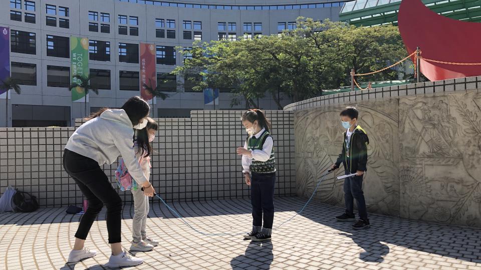 Kids playing games with an HKUST student on campus