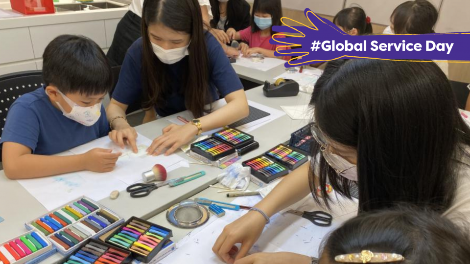 Volunteers helping children with their drawings.