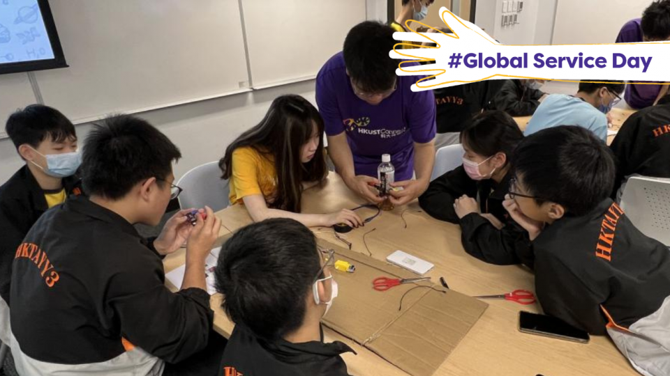 Volunteers helping students with their STEM project.