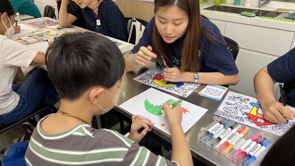 Volunteer coaching a child drawing