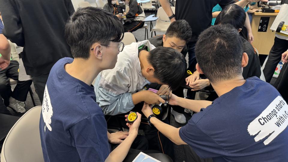 Volunteers building cars with the students.